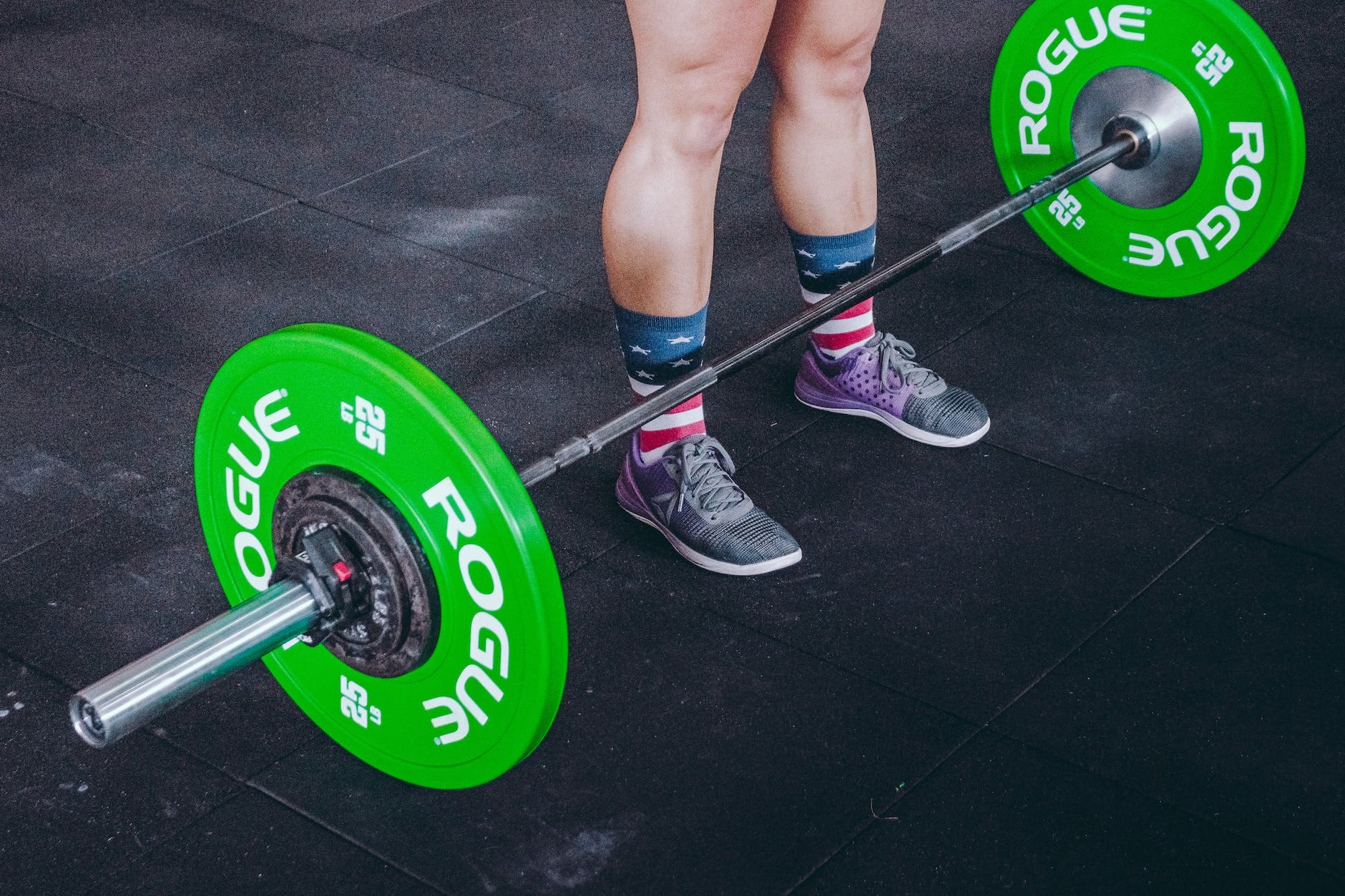 person standing in front of green and gray barbell